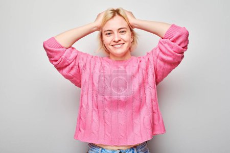 Téléchargez les photos : Portrait de visage souriant jeune femme blonde touchant la tête et se réjouissant, célébrant la victoire isolée sur fond de studio blanc, banne publicitaire - en image libre de droit