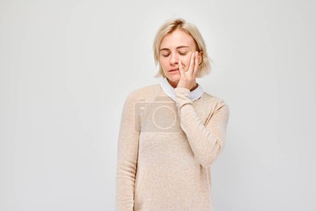 Portrait von Mädchen mit traurigem Gesicht beleidigt und weint auf weißem Hintergrund. Nerven, Stress, Unsicherheit