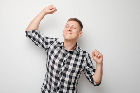 Photo for Portrait of smiling face man clenching fists and rejoicing, celebrating victory isolated on white studio background, advertising banne - Royalty Free Image