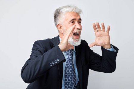 Portrait of senior businessman in suit shouting loudly with hands, news, palms folded like megaphone isolated on white backgroun