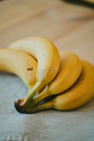 Téléchargez les photos : Gros plan d'un bouquet de bananes sur un fond de table de cuisine en bois - en image libre de droit