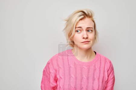 Portrait of girl with sad face offended and crying on white background. Nerves, stress, uncertainty concep