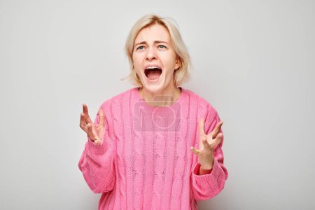 Porträt eines Mädchens, das vor Wut schreit, ausrastet, Zusammenbruch auf weißem Hintergrund. Depression, Unsicherheit, nervöser Stress