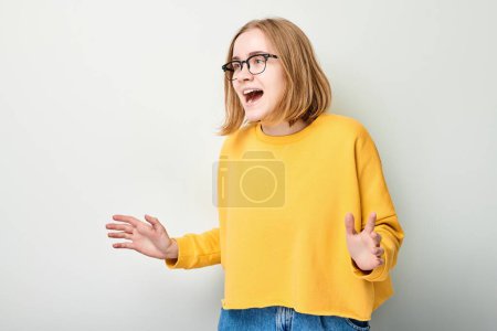 Foto de Retrato estudiante chica feliz cara sonriendo alegremente con las palmas levantadas y la boca abierta conmocionado aislado en fondo blanco estudio - Imagen libre de derechos
