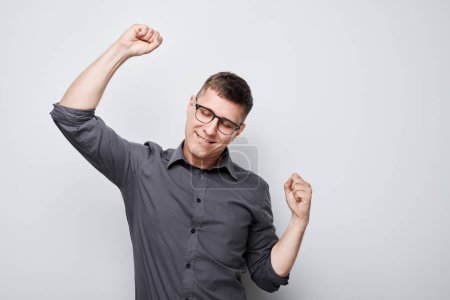 Foto de Retrato del sonriente hombre de la cara apretando puños y regocijándose, celebrando la victoria aislada sobre fondo blanco del estudio, publicidad banne - Imagen libre de derechos