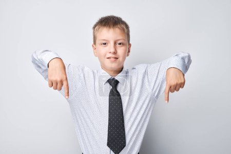 Foto de Sonriente joven con camisa y corbata extendiendo los brazos, de pie sobre un fondo claro - Imagen libre de derechos