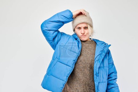 Téléchargez les photos : Femme en tenue d'hiver regardant réfléchi sur un fond clair. - en image libre de droit