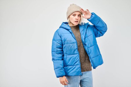 Foto de Mujer en traje de invierno con expresión pensativa, piensa, elige aislado sobre fondo claro - Imagen libre de derechos