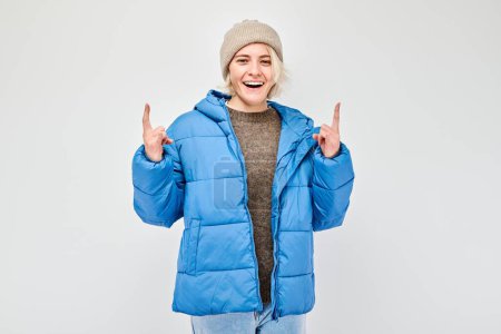 Téléchargez les photos : Femme en tenue d'hiver pointe du doigt l'espace vide pour le texte ou la publicité produit - en image libre de droit