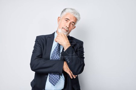 Photo for Mature businessman in suit pondering with a pensive face, thinking chooses on white background - Royalty Free Image