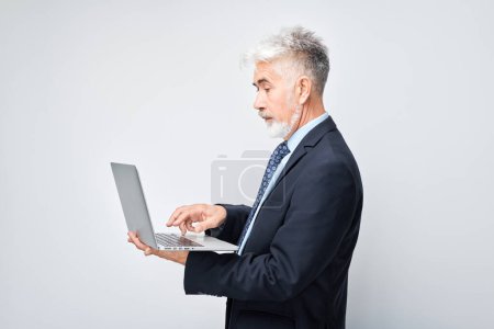 Photo for Senior businessman using laptop on white background. - Royalty Free Image