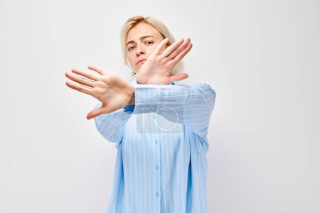 Foto de Mujer haciendo gesto de stop con las manos, señalando límite o rechazo, aislado sobre fondo blanco. - Imagen libre de derechos