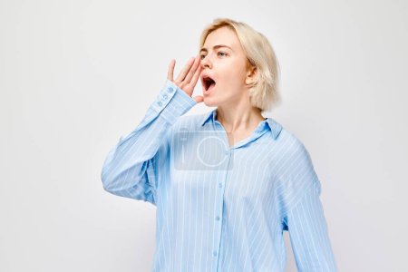 Porträt eines blonden Mädchens, das laut schreit, mit Händen, Nachrichten, Handflächen gefaltet wie ein Megafon, isoliert auf weißem Hintergrund