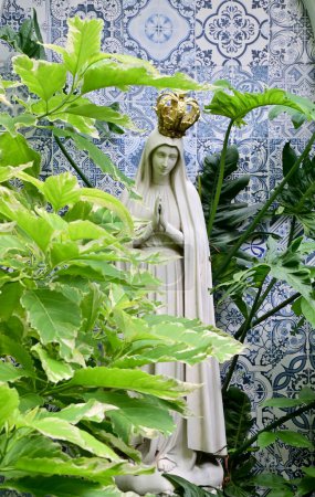 Nahaufnahme der Statue Unserer Lieben Frau der Gnade Jungfrau Maria mit natürlichem Hintergrund im Garten, Thailand. Selektiver Fokus.