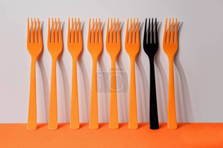 Téléchargez les photos : Cinq fourchettes en plastique orange sur fond orange et blanc - en image libre de droit
