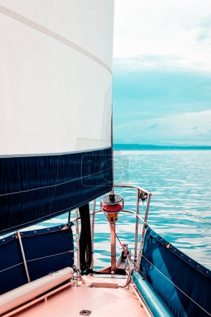 Segel und Spitze eines Segelbootes an einem ruhigen Tag auf dem Wasser