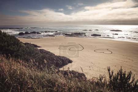 Téléchargez les photos : Deux cœurs gravés dans le sable sur la plage de l'Oregon - en image libre de droit
