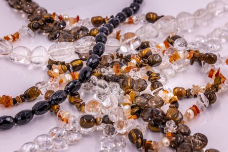 Collection of semi-precious stone necklaces on a white surface