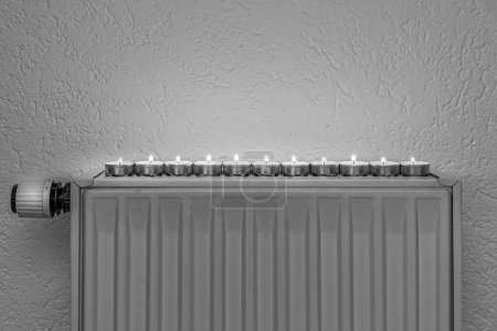 Tea candles on a wall heater, concept of alternative heeating possibilities during the energy crisis and turning down the regular heating sources