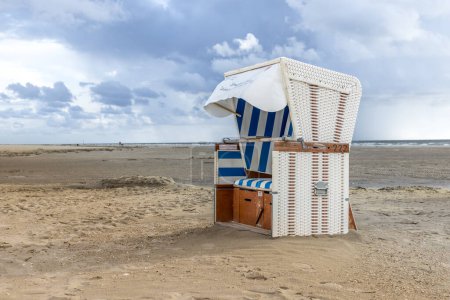 Téléchargez les photos : Chaise de plage à capuche sur la plage à la mer du Nord - en image libre de droit