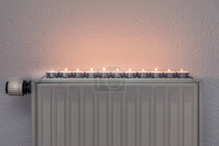 Tea candles on a wall heater, concept of alternative heeating possibilities during the energy crisis and turning down the regular heating sources