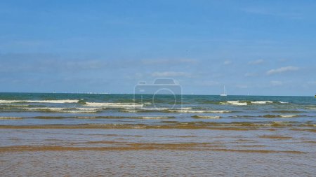 Belle mer avec sable, yacht, vagues sur l'eau et ciel bleu. Fond naturel pour les vacances d'été.