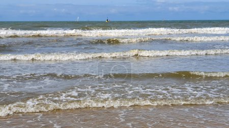Belle mer avec sable, yachts, vagues sur l'eau et ciel bleu. Fond naturel pour les vacances d'été.