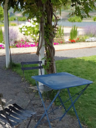 Summer metal table and chairs for family near the river. Place for relaxing in park with panoramic view. 