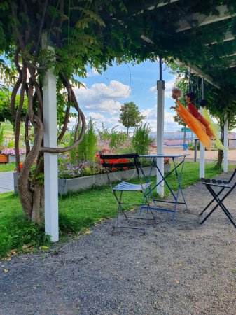 Metalltisch und Stühle für die Sommerruhe am Fluss. Park mit Panoramablick. 