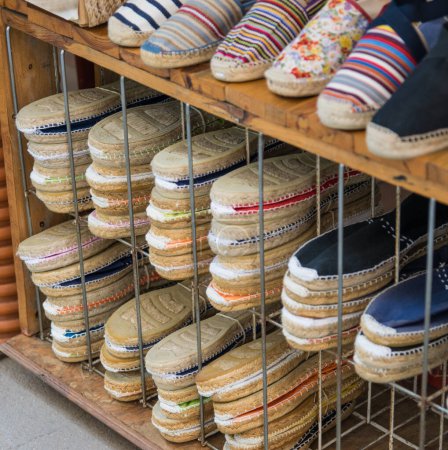Kollektion von sommerlichen bunten Schuhen für Frauen im Holzschuhfach bei sonnigem Wetter.