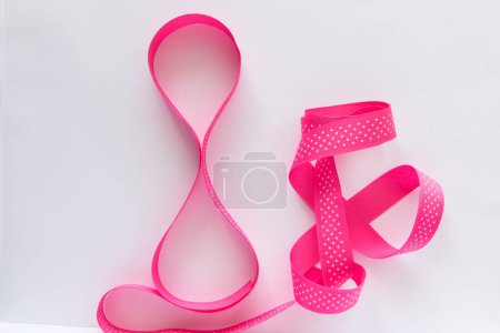 8. März - Internationaler Frauentag. Pinkfarbenes mattes Stoffband auf weißem Hintergrund.
