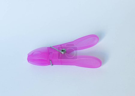 Plastic pink clothespin on a white isolated background.