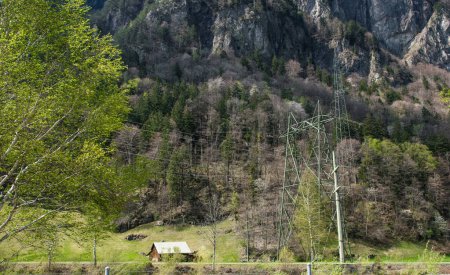 A little old wood house between mountains with much trees. Nature background with Alps in Switzerland, Europe.