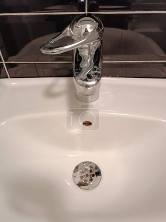 Cuarto de baño lavabo de cerámica blanca WC lavabo grifo de agua grifo de baño higiene. Foto de alta calidad