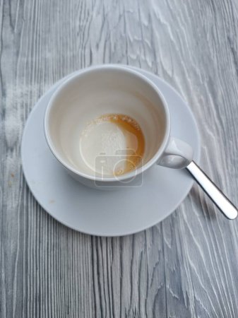 Leere Kaffeetasse nach dem Getränk auf dem grauen Tisch des Cafés. Hochwertiges Foto. Bodensatz in der Tasse. Kaffee am Morgen. 