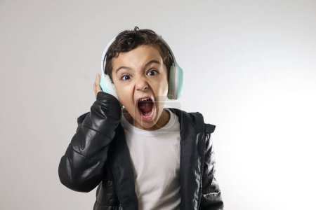 Junge hört Musik über Kopfhörer und schreit