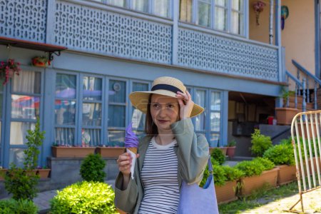 Téléchargez les photos : Une femme mange de la glace au vin dans le centre historique de Tbilissi, en Géorgie. Photo de haute qualité - en image libre de droit