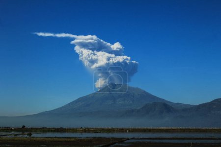 Un momento de erupción del Monte Merapi con espeso humo de ceniza apareció detrás del Monte Merbabu a las 08.02 am en Ambarawa Semarang, Indonesia el 11 de mayo de 2018.