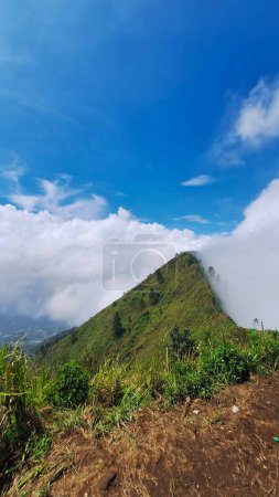 One of the highest peaks of Mount Andong shrouded in clouds with its right and left side of the gorge overgrown with various kinds of wild vegetation Magelang, Indonesia on December 29, 2023.