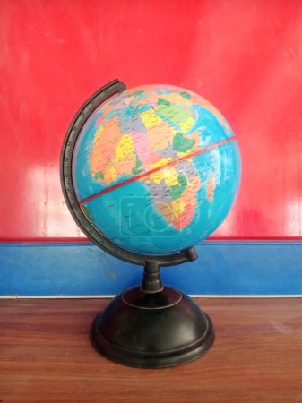 globo del mapa del mundo con fondo azul y rojo. Un mapa del mundo se muestra en un globo situado sobre un llamativo fondo de azul y rojo, creando un efecto visual vívido y dinámico.
