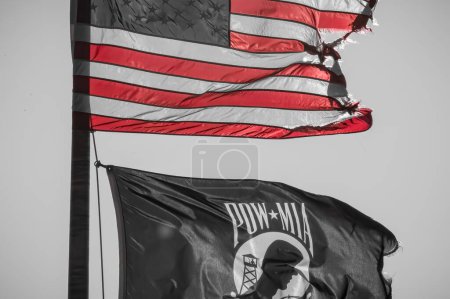 Téléchargez les photos : Dramatique déchiré drapeau des États-Unis volant au-dessus de POA MIA drapeau. Photo de haute qualité - en image libre de droit