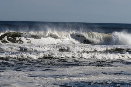Ocean waves crashing off the beach . High quality photo