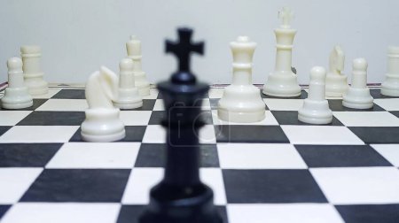 Ein einzelner schwarzer König gegen weiße Soldaten im Schachspiel, Ein-Mann-Armee-Konzept. 