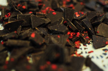 Dark chocolate pieces crushed on a dark background, view from above. High quality photo