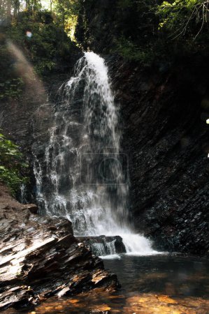 Una hermosa vista del agua que fluye a un ritmo alto sobre el lecho de roca formando cascadas en el camino hacia abajo de la montaña. Foto de alta calidad