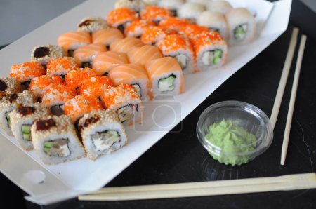 Foto de Comida japonesa de sushi. Rollos de Maki ands con atún, salmón, camarones, cangrejo y aguacate. Vista superior de sushi surtido. Rollo de sushi arco iris, uramaki, hosomaki y nigiri. .. Foto de alta calidad - Imagen libre de derechos