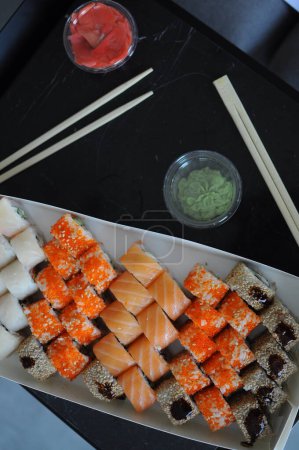 Foto de Comida japonesa de sushi. Rollos de Maki ands con atún, salmón, camarones, cangrejo y aguacate. Vista superior de sushi surtido. Rollo de sushi arco iris, uramaki, hosomaki y nigiri. .. Foto de alta calidad - Imagen libre de derechos