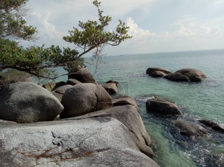 Ruhiger und sauberer Strand auf der Insel Bangka-Belitung in Indonesien. Große Granitfelsen, grüne Bäume und weißer Sand sind so schön, um Ihren Urlaub zu genießen.