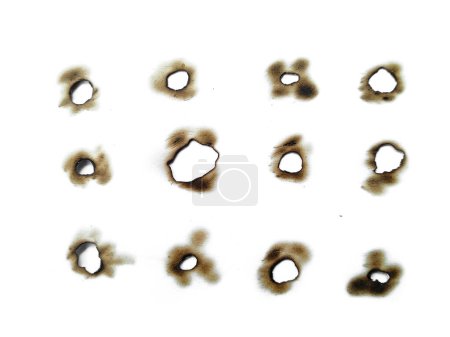 Téléchargez les photos : Fire holes in white paper. Collection of burnt holes in a piece of paper isolated on white background - en image libre de droit