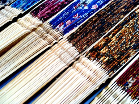 Téléchargez les photos : Kipas Tangan Motif Batik ou ventilateur main Batik en bambou et tissu batik. ventilateur à main motif batik isolé sur fond blanc. Ventilateur à main Bali Indonésie - en image libre de droit